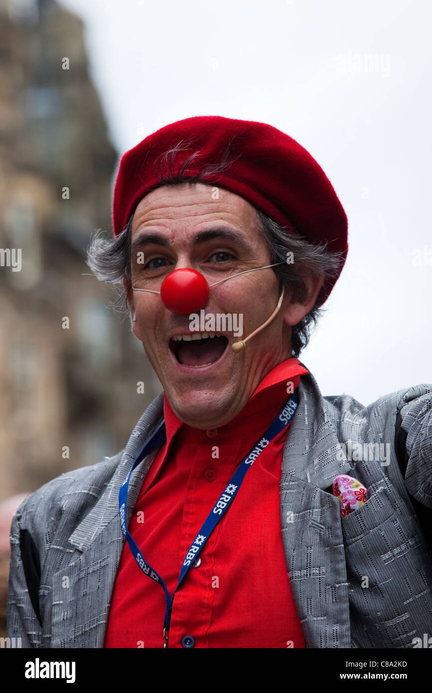 Artiste de rue habillé en clown et avec un nez rouge, divertissant au Fringe Festival, High Street, Edinburgh, Ecosse Banque D'Images