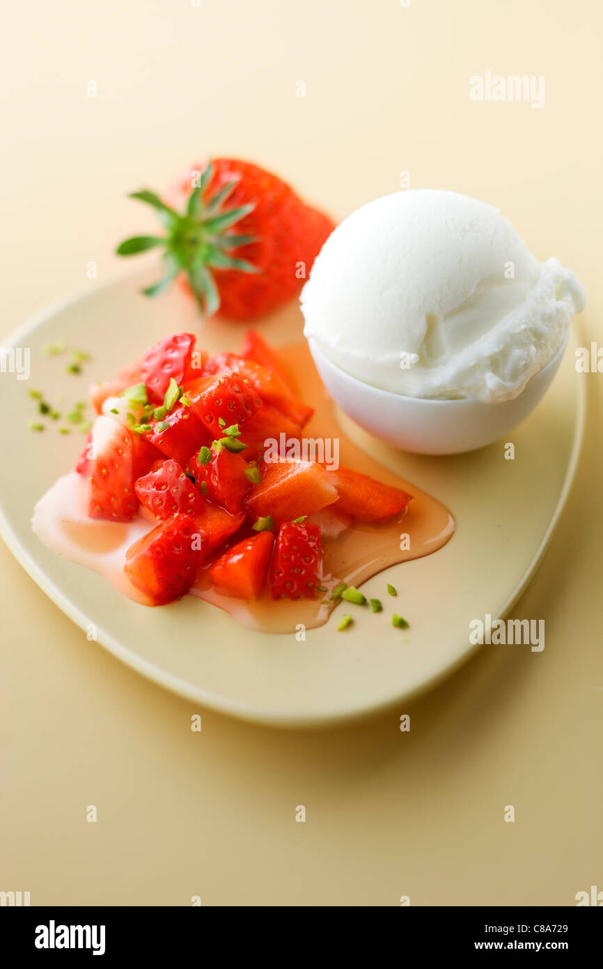 Salade de fruits aux fraises avec pistaches concassées ,sorbet agrumes Banque D'Images