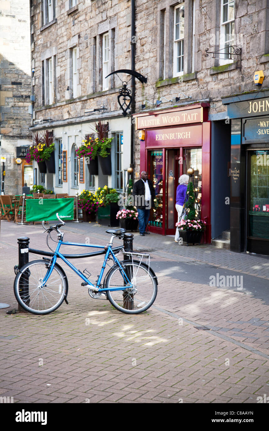 Edimbourg, Ecosse, push, location de vélo bleu, se pencha, parqués pour 2 postes à l'extérieur noir flower shop Banque D'Images