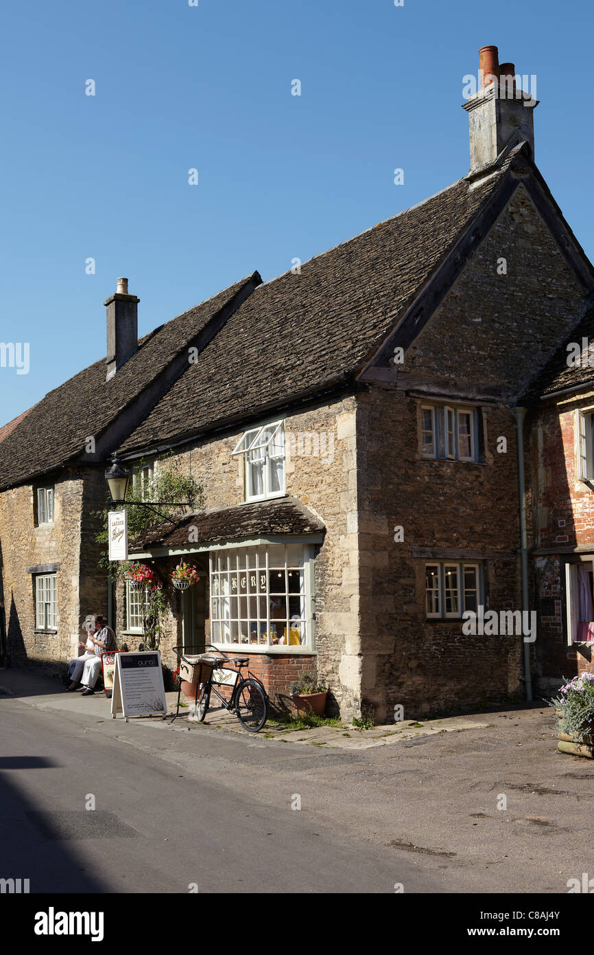 Deux touristes manger des glaces creem en dehors de la salle de thé, Village de Lacock, Wiltshire, Angleterre, Royaume-Uni Banque D'Images