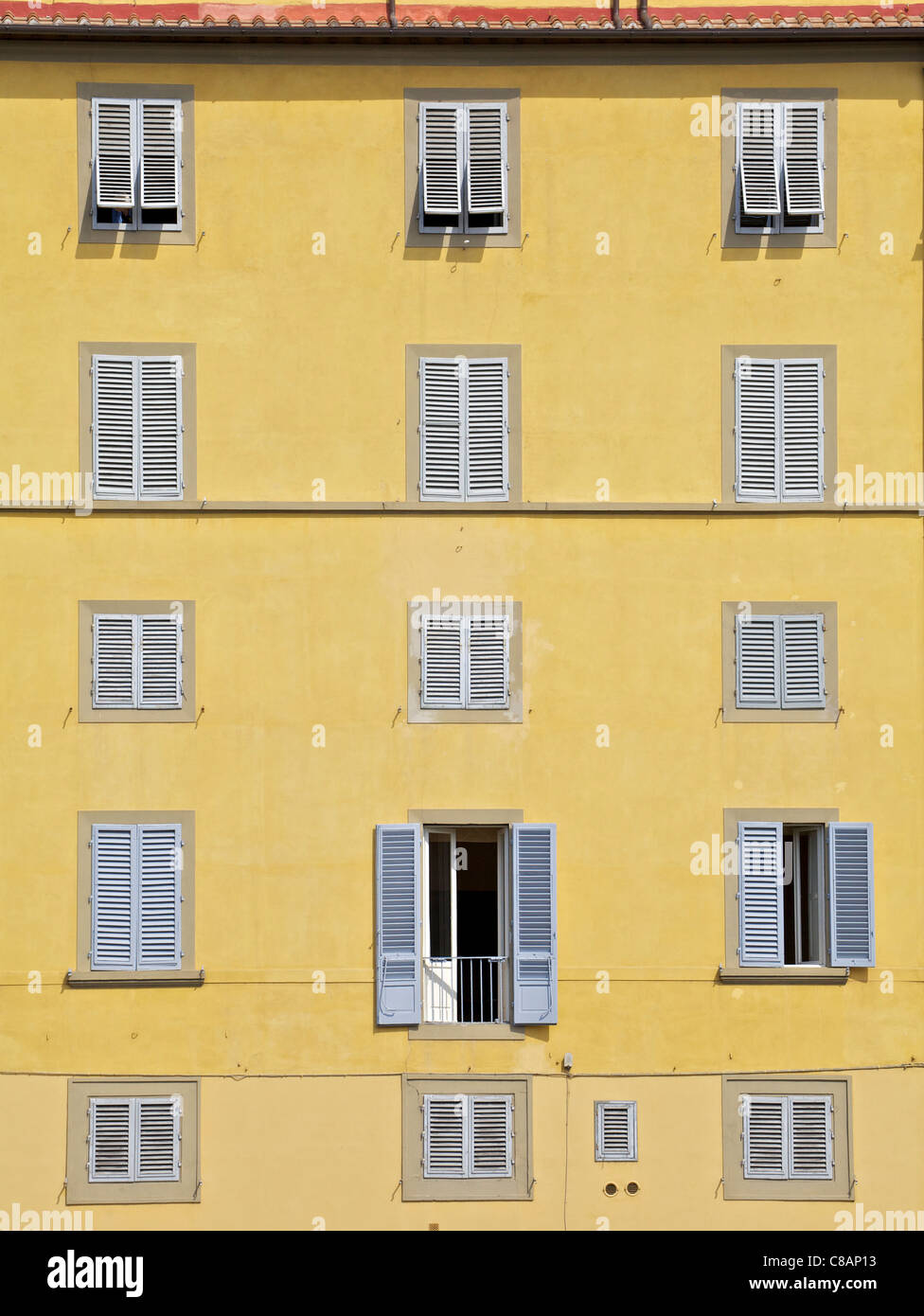 Fenêtres de Florence contre un mur de plâtre jaune pâle Banque D'Images