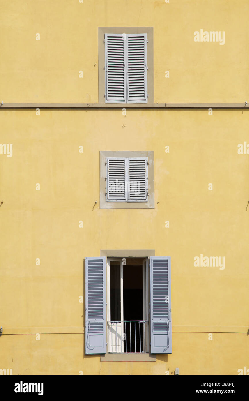 Trois fenêtres de Florence contre un mur de plâtre jaune pâle Banque D'Images