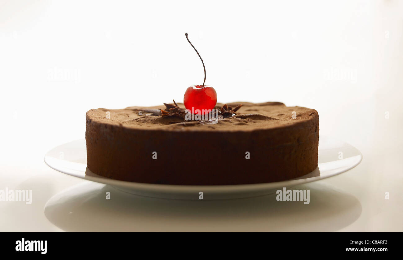Gâteau au chocolat décoré d'une cerise confite Banque D'Images
