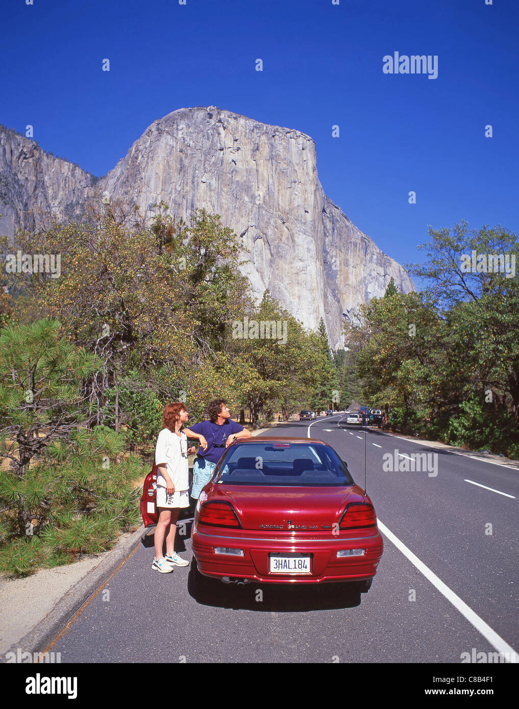 Couple avec voiture de location dans la région de Yosemite National Park, California, United States of America Banque D'Images