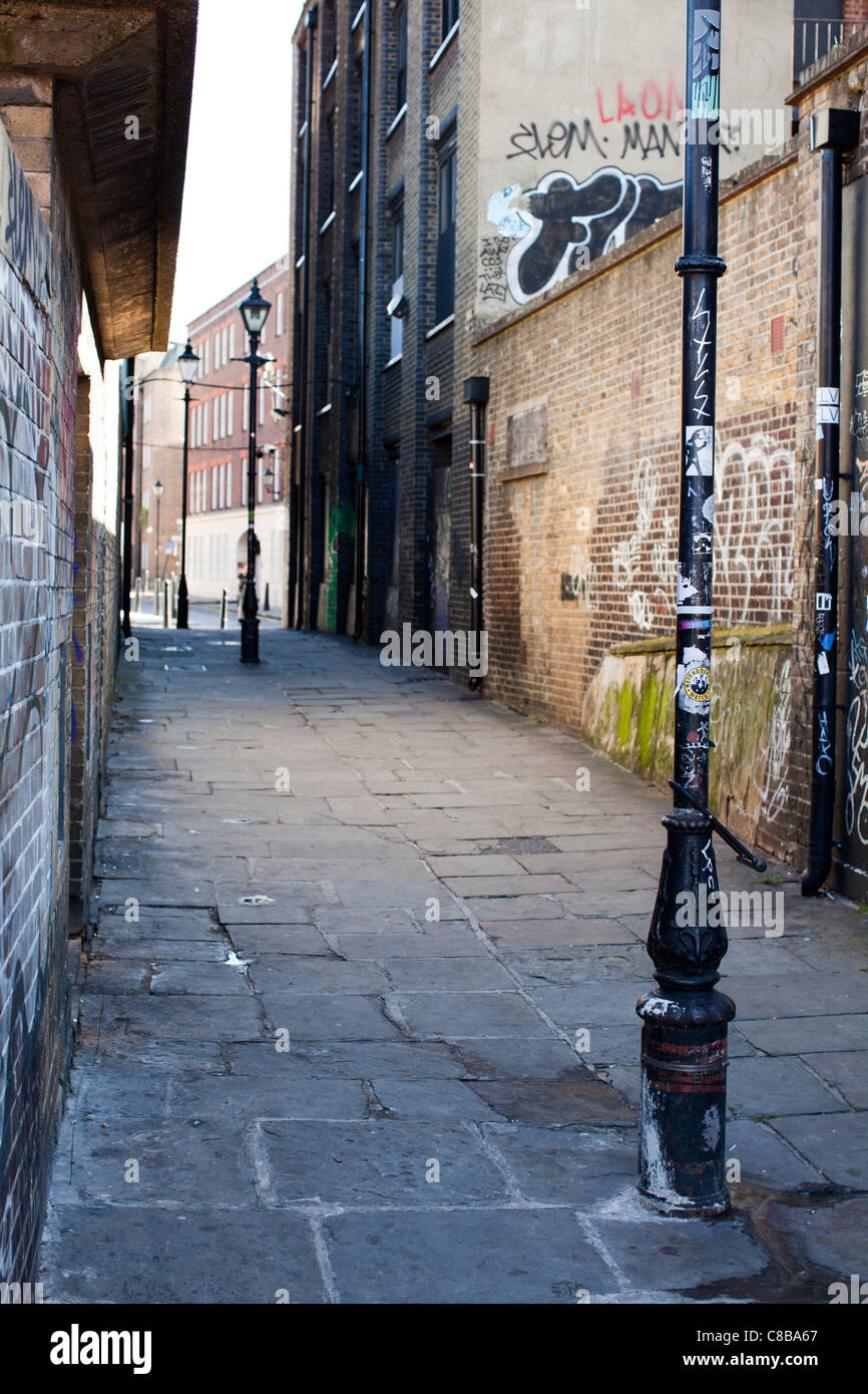 Une ruelle à Shoreditch couvert de graffitis. Londres. UK. Banque D'Images
