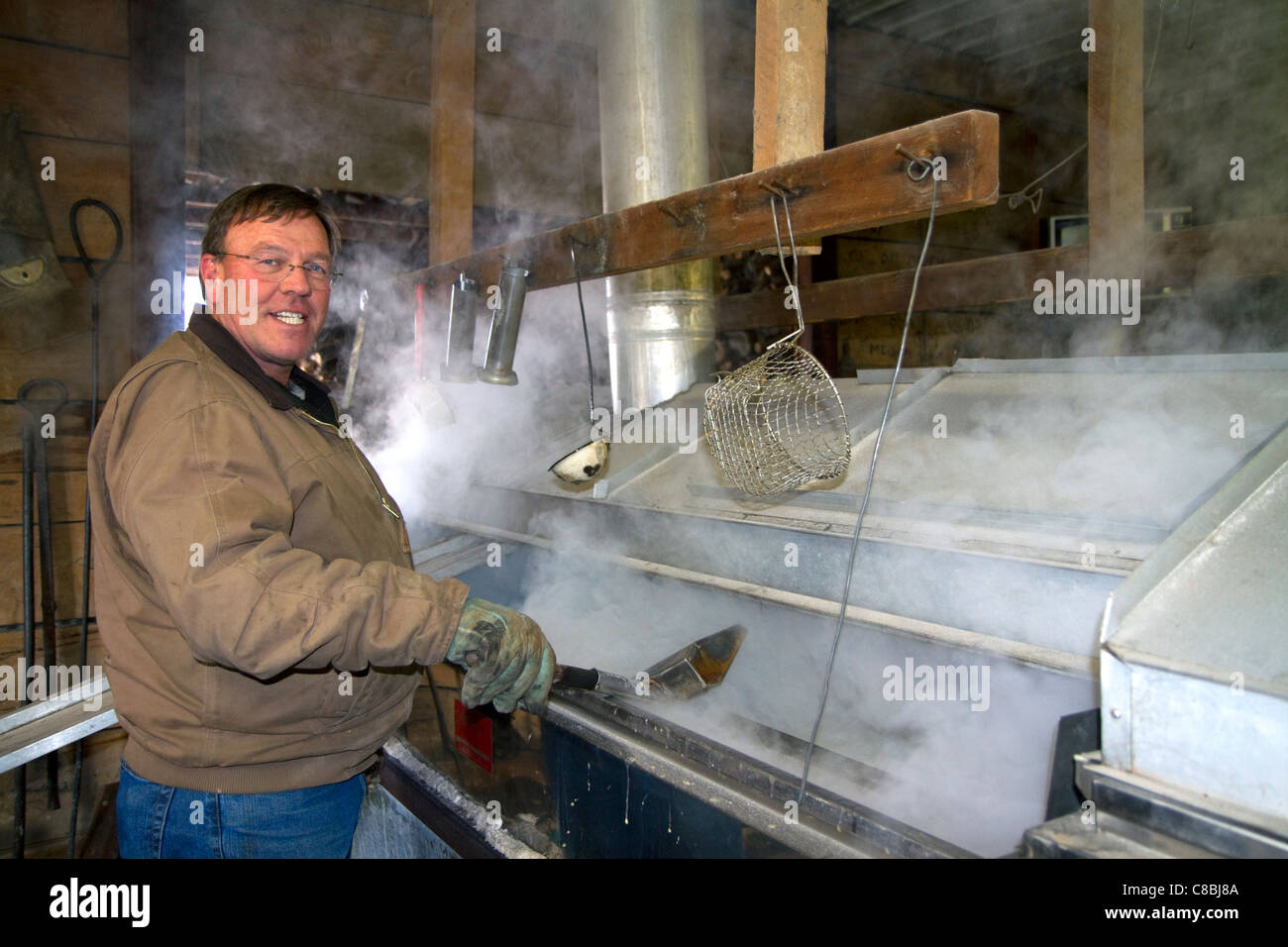 La sève d'érable bouillant travailleur dans une cabane à sucre à Lake Odessa, Michigan, USA. Banque D'Images