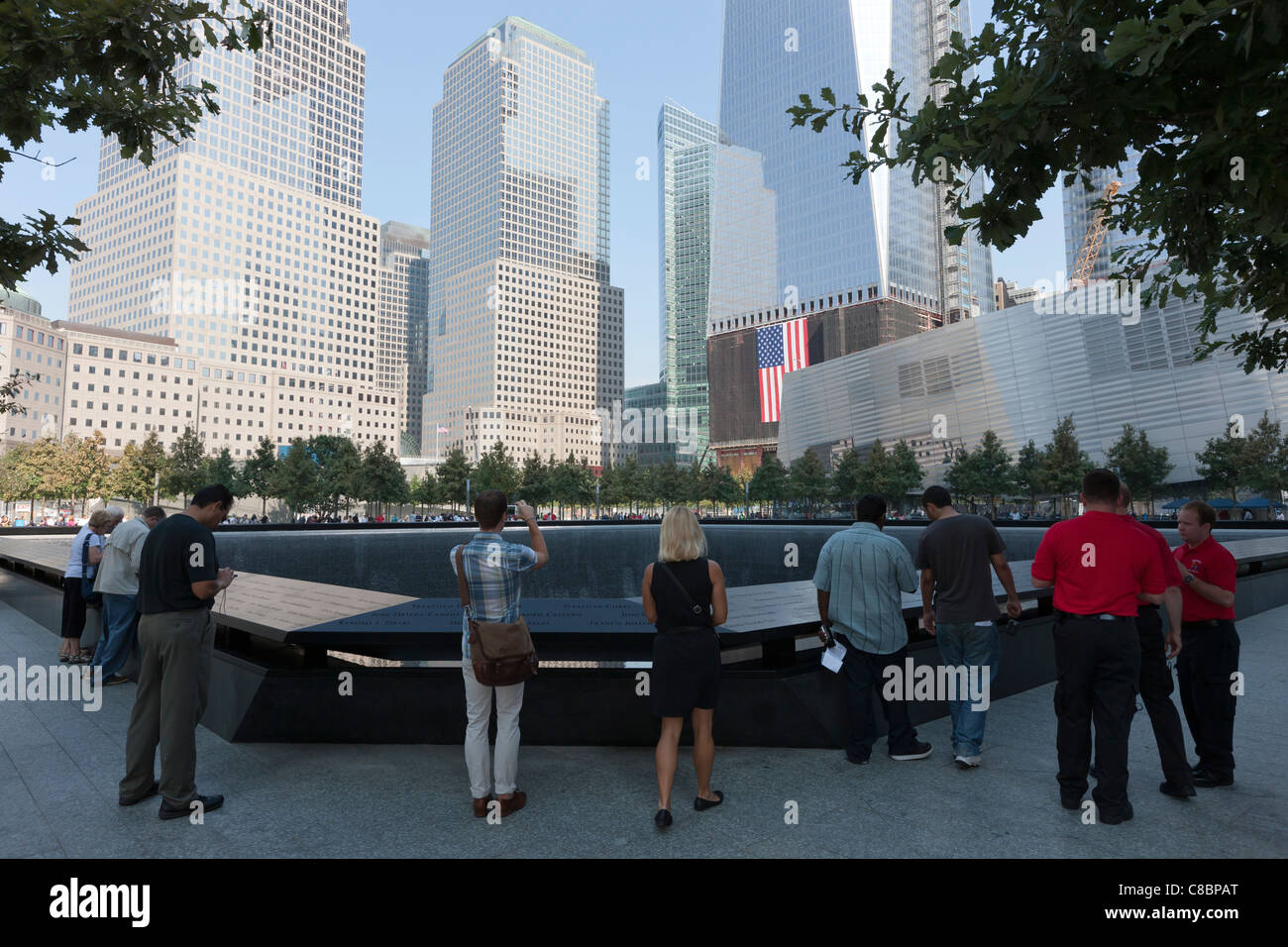 Les visiteurs s'en tenir à la piscine du Sud au Mémorial National du 11 septembre à New York. Banque D'Images