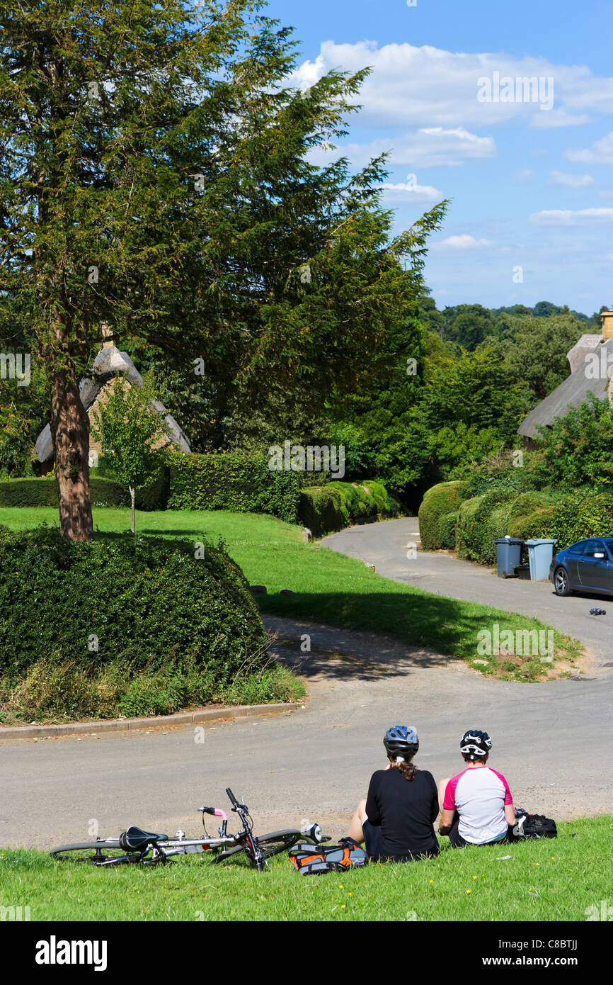Les cyclistes se reposant dans le village de Cotswold Chadlington, Oxfordshire, England, UK Banque D'Images