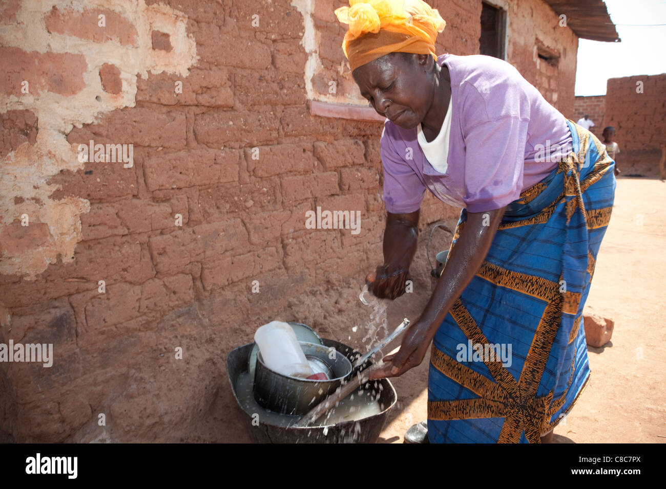 Une femme se lave les mains à l'extérieur de son domicile de Mongu, Zambie, Afrique du Sud. Banque D'Images