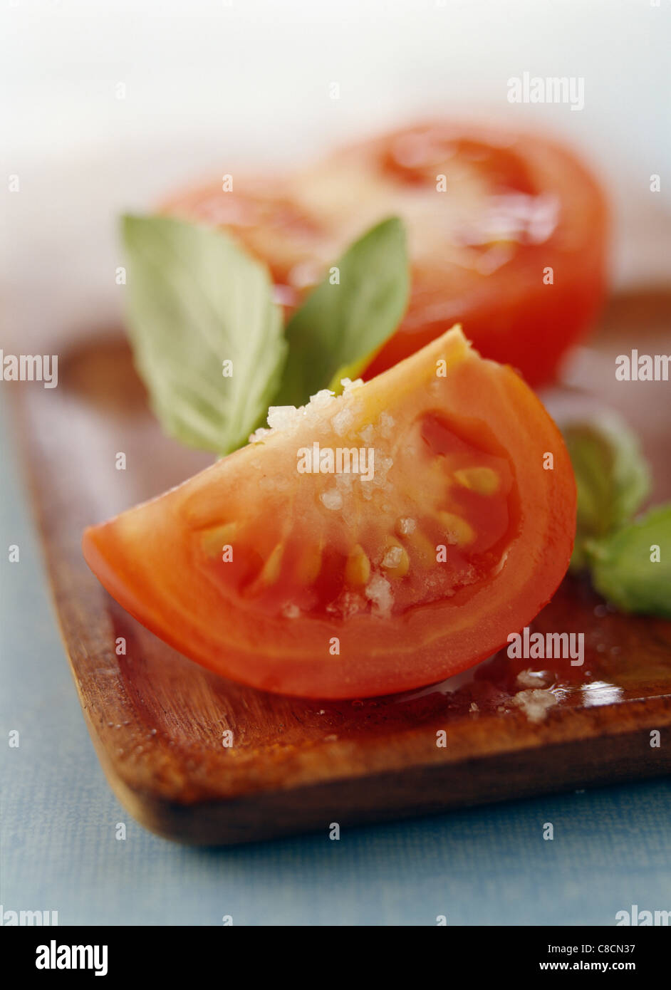 Tomates cerise, coupées en quartiers, le basilic et le gros sel Banque D'Images