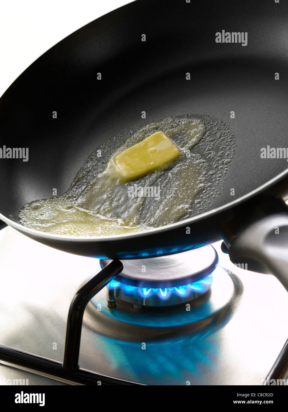 Morceau de beurre en train de fondre dans un poêlon sur un réchaud à gaz  Photo Stock - Alamy