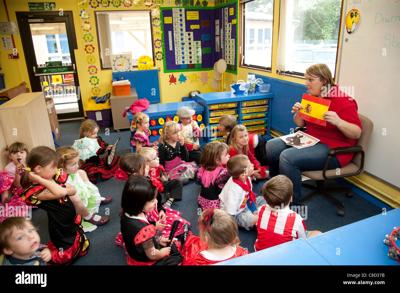 Journée internationale des enseignants - une femme avec des enfants en classe dans une école primaire de parler de l'Espagne, Pays de Galles, Royaume-Uni Banque D'Images