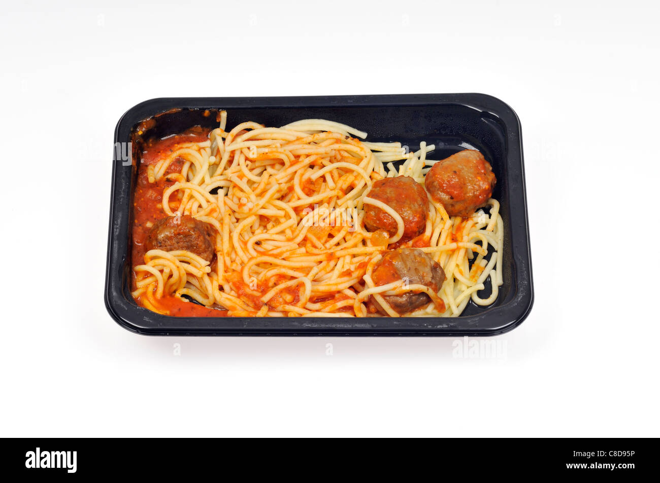 Le bac d'un four micro-ondes Le spaghetti cuit et boulettes de readymeal sur fond blanc, découpe. Banque D'Images