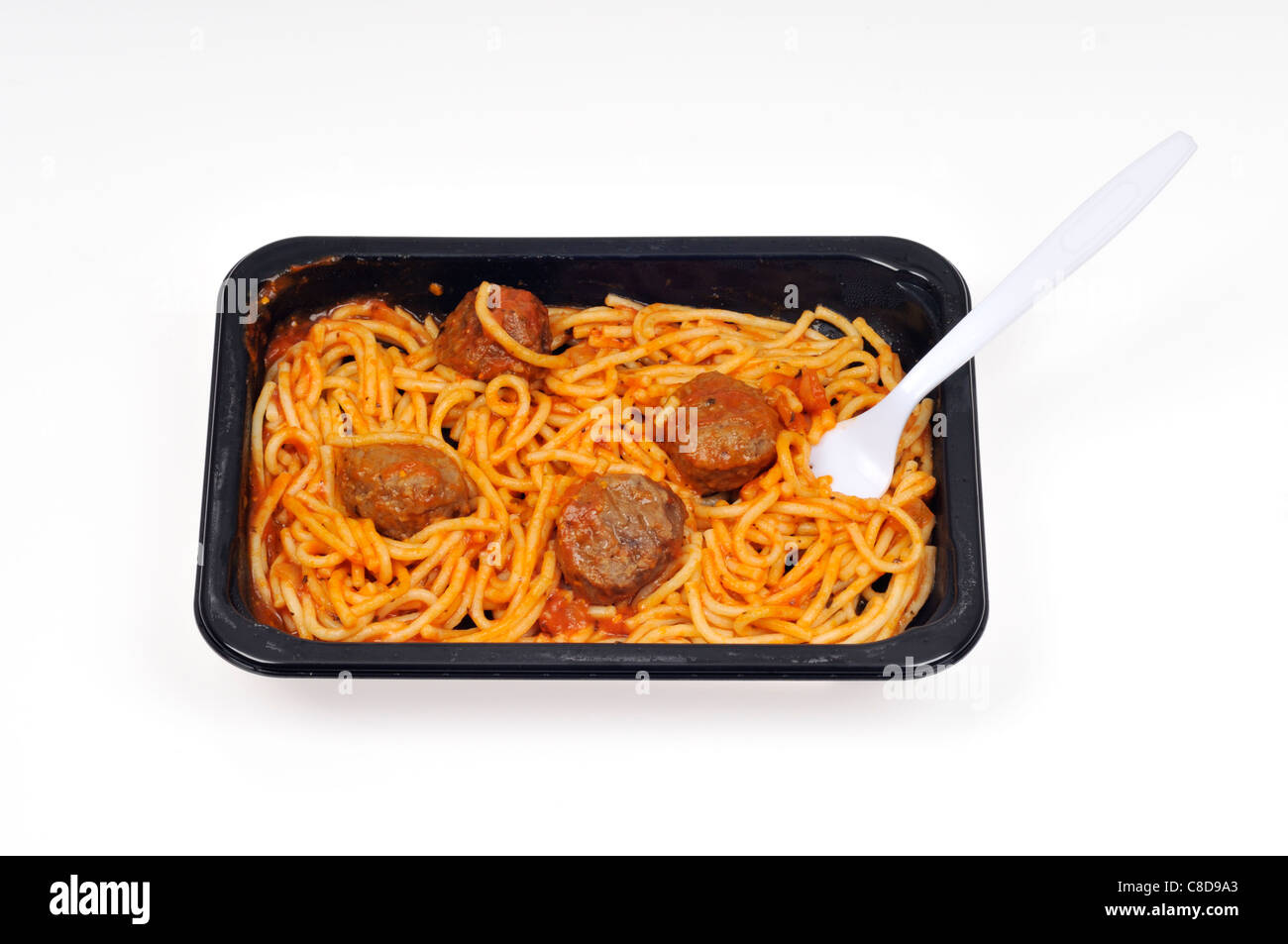 Plateau de repas cuits prêts de spaghetti et boulettes de viande avec une fourchette en plastique jetable sur fond blanc. Banque D'Images