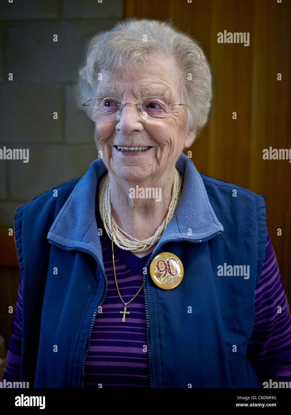 femme de 90 ans à son anniversaire et portant un badge lapel approprié. Angleterre Royaume-Uni Europe peuple non-agénaire Banque D'Images