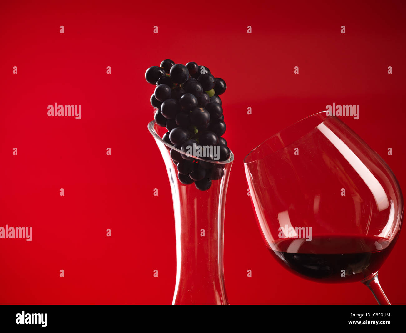 Détail de verre de vin rouge et la carafe, avec truss de raisins Banque D'Images