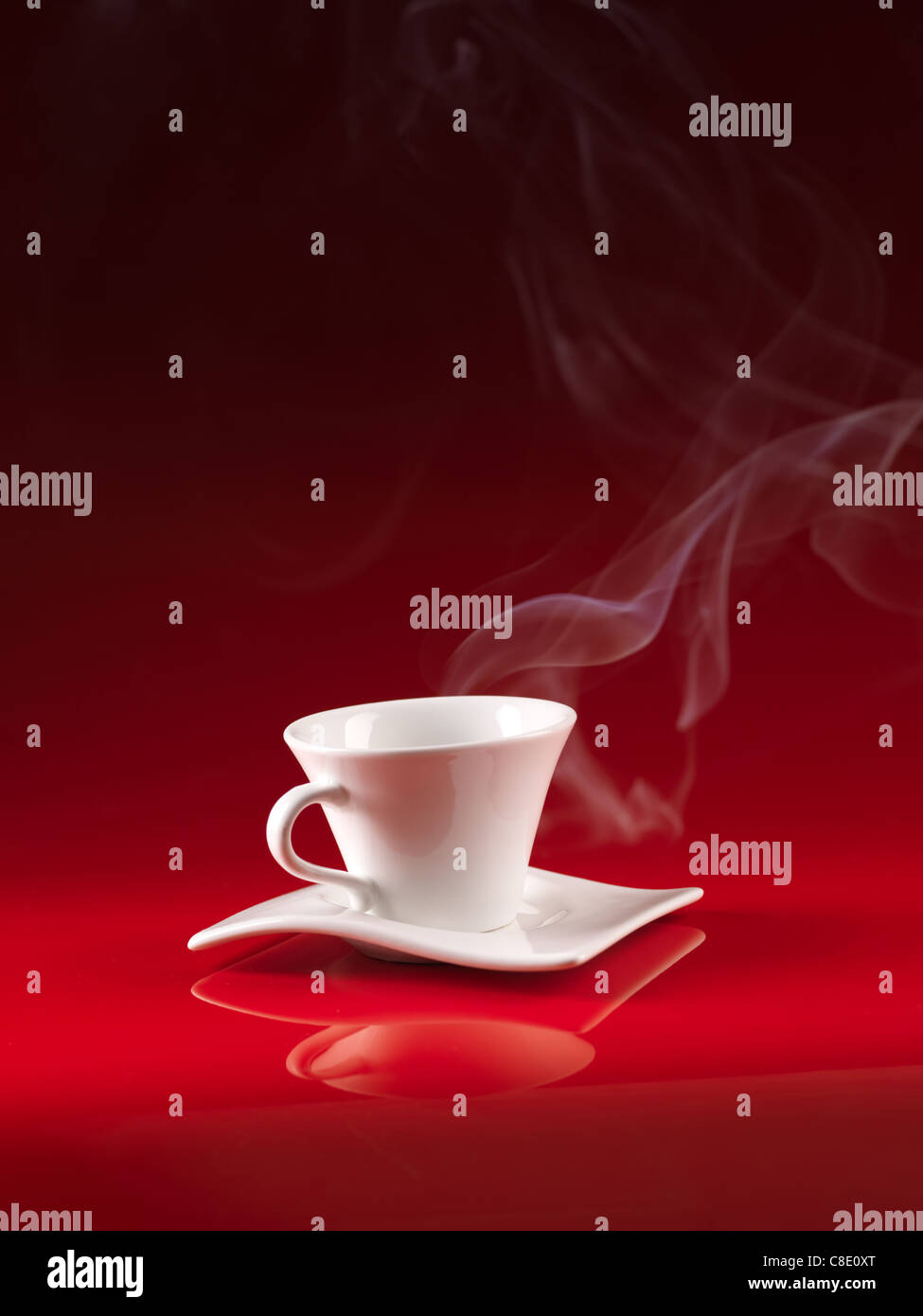 Tasse et soucoupe blanc avec du café chaud, sur fond rouge Banque D'Images