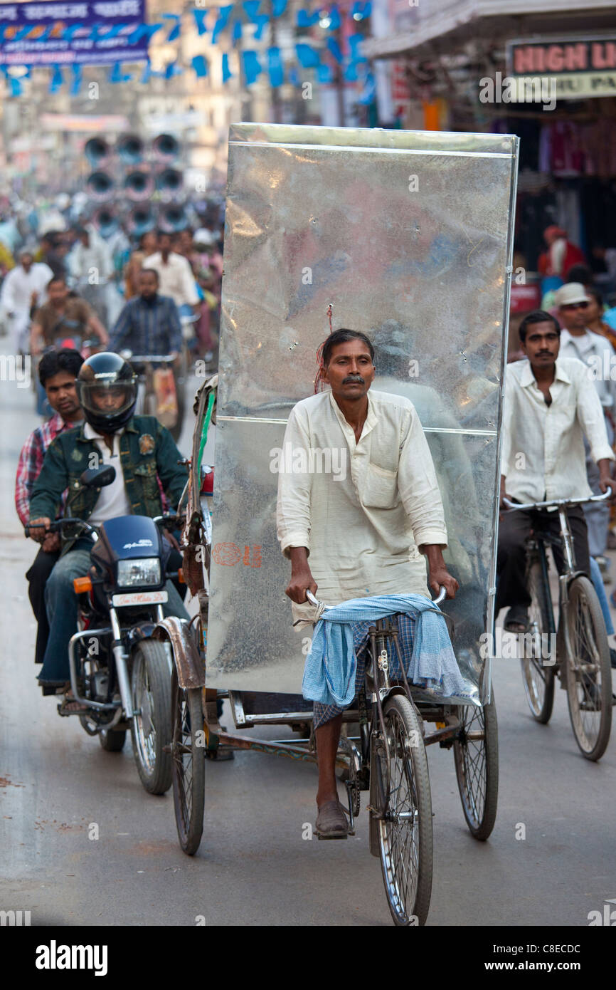 L'homme indien pousse-pousse de conduite avec une charge lourde en scène de rue à ville de Varanasi, Benares, Inde du Nord Banque D'Images