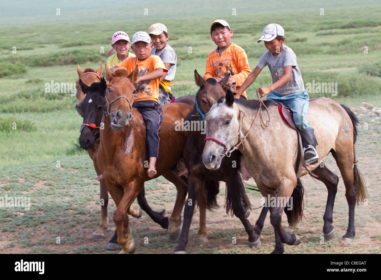 Les enfants pratiquant la course de chevaux de Mongolie Banque D'Images