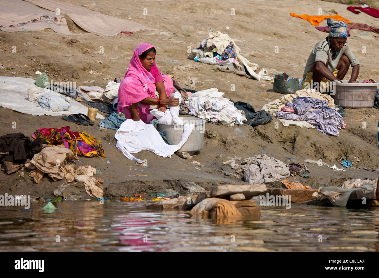 L'homme et de la femme indienne de faire la lessive dans les eaux du Gange à Cabua Pandey Ghat dans la ville de Varanasi, Benares, Inde Banque D'Images
