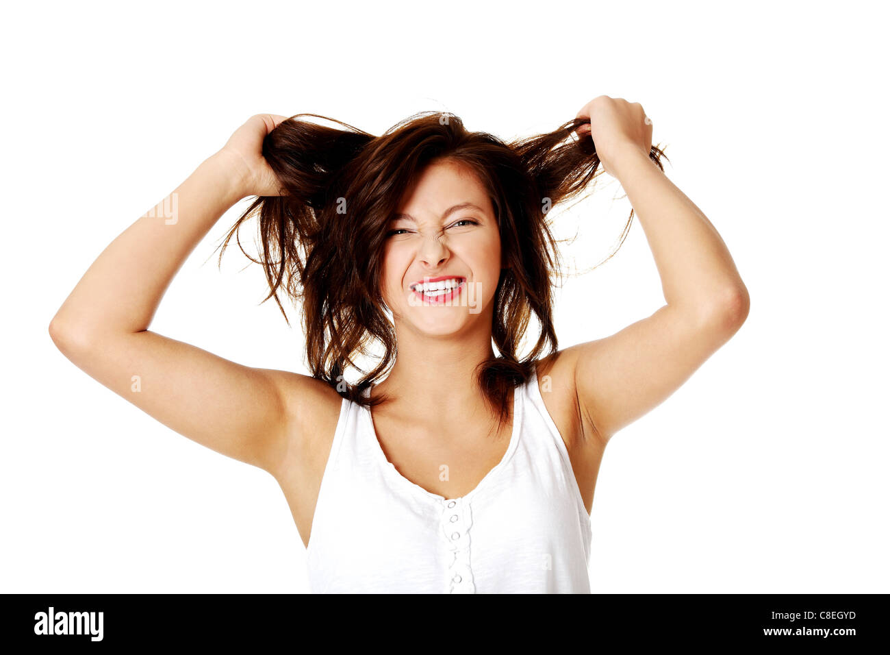 Jeune fille de race blanche mad tirant ses cheveux. Isolé sur blanc. Banque D'Images