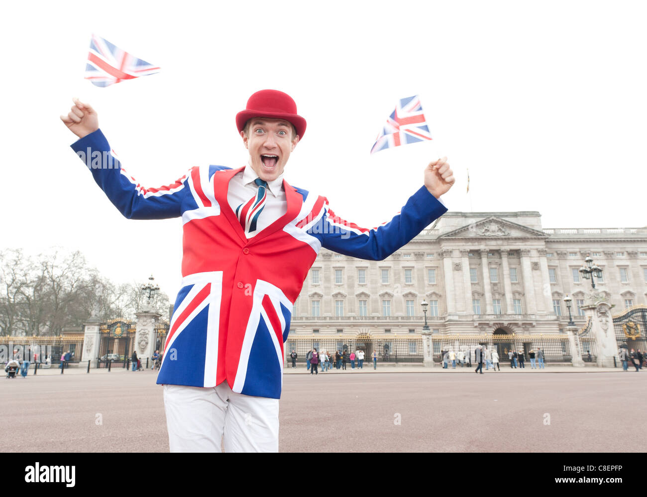 Homme portant patriotique Union Jack agitant des drapeaux de l'Union tenue à Buckingham Palace, Londres. Brexiteer, Brexit. Banque D'Images