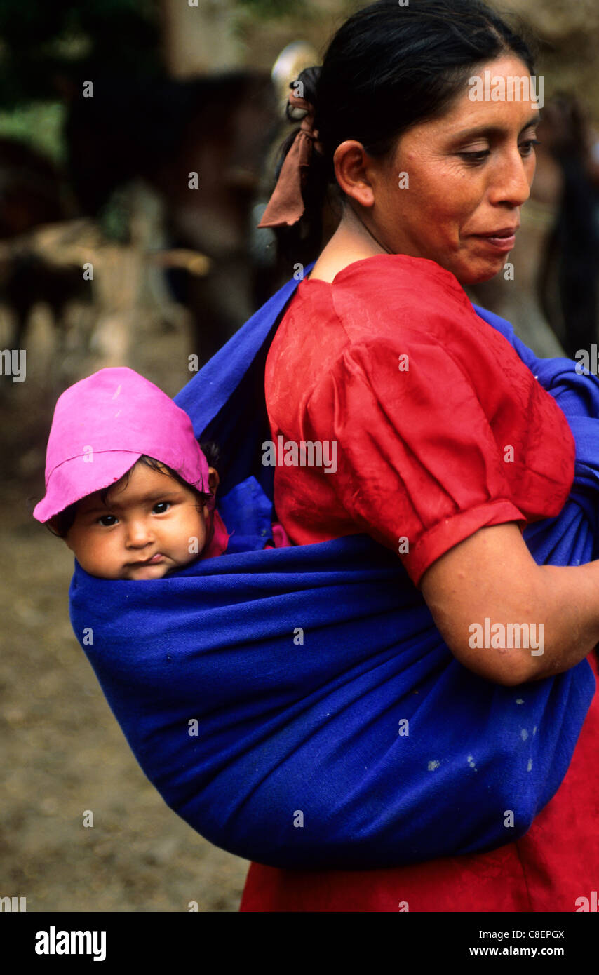 Cusco Perou Femme En Robe Rouge Avec Bebe Dans Un Chapeau Rose Dans Un Tissu Bleu Sur Le Dos Photo Stock Alamy