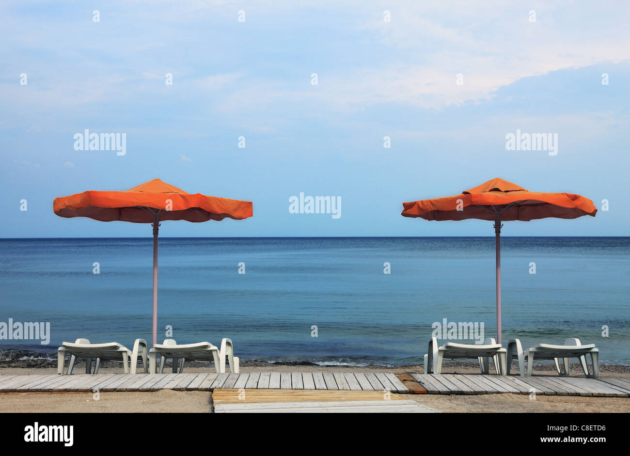Image de parasols et chaises longues orange blanc sur une plage Banque D'Images