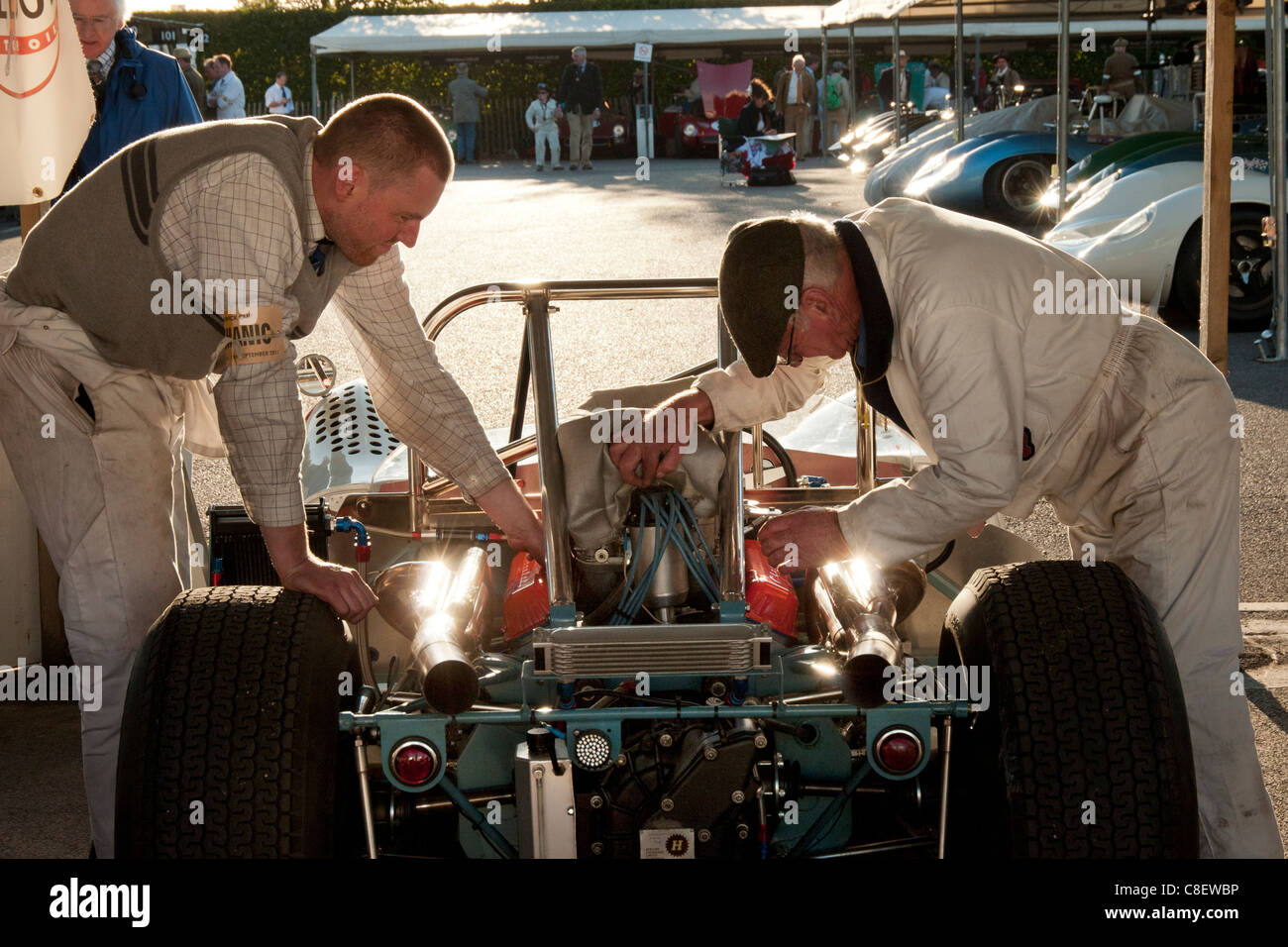 Mécaniciens travaillant sur une vieille voiture de Formule Un dans le paddock au Goodwood Revival réunion de courses Banque D'Images