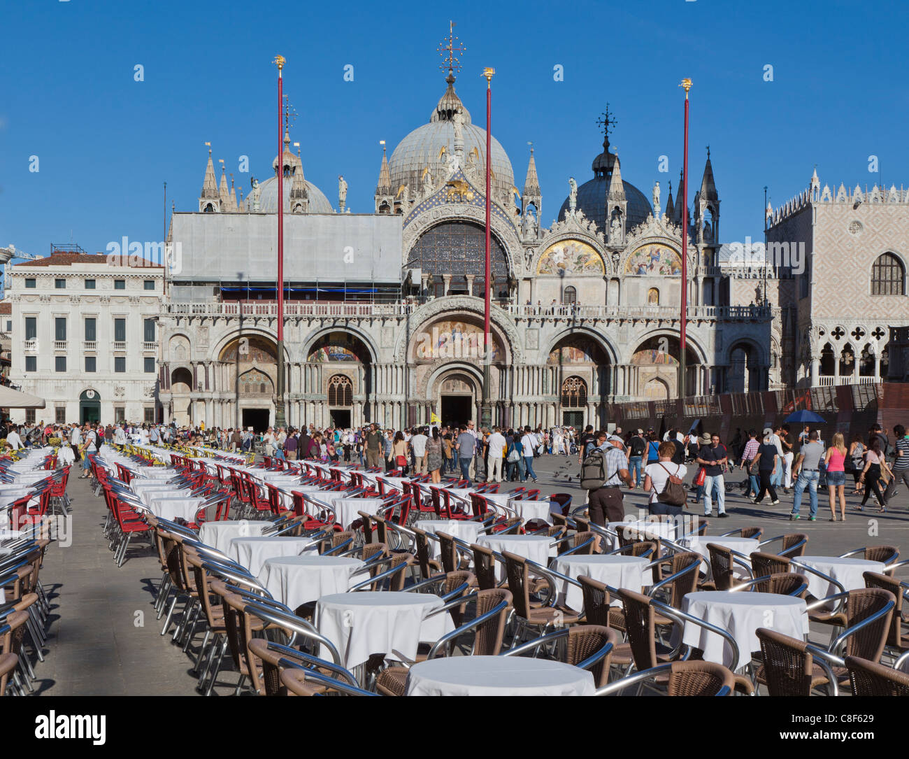 Un restaurants tables et chaises en face de la Basilique de San Marco. Banque D'Images