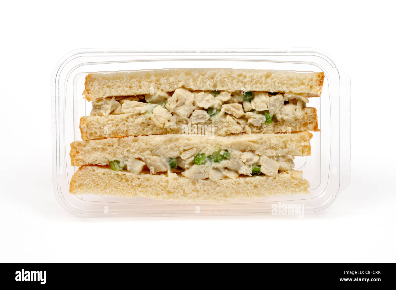 Sandwich à la salade de poulet avec Mayo et le céleri sur pain blanc en plastique claire paquet à rendez-vous contenant à emporter sur fond blanc. Banque D'Images
