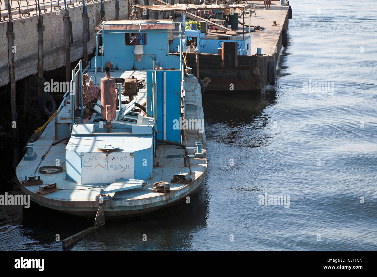 En regardant légèrement vers le bas sur un remorqueur de bateau amarré à la jetée de l'appareil photo face arrière avec reflet dans l'eau calme, du Nil Egypte Banque D'Images