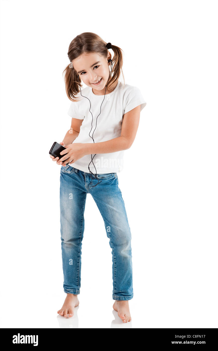 Petite fille danser tandis que d'écouter la musique avec un lecteur MP3, isolated on white Banque D'Images