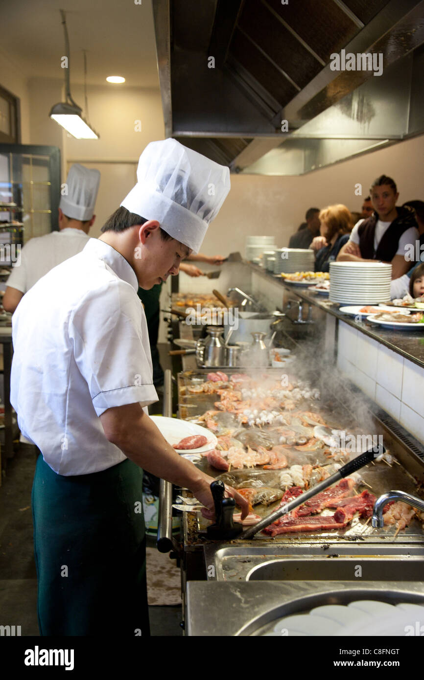 Chef chinois à la cuisson des aliments sur le gril dans un restaurant chinois à Rome Italie Banque D'Images