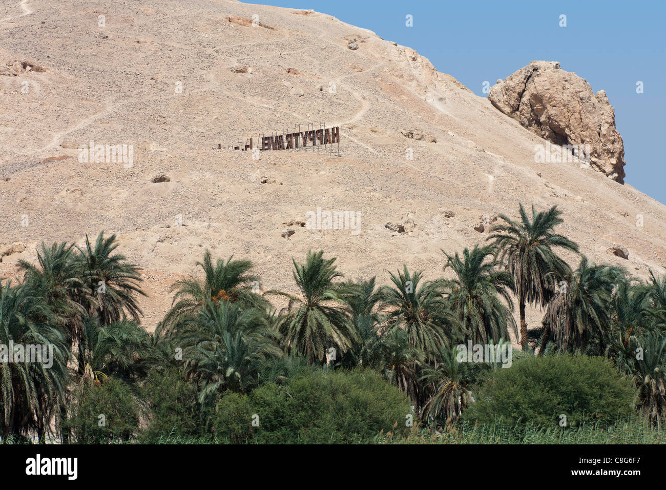 Panneau de bienvenue avec style Hollywood palms en face sur les montagnes à Sharona sur le protectorat d'Assouan Louxor, Egypte frontière Banque D'Images