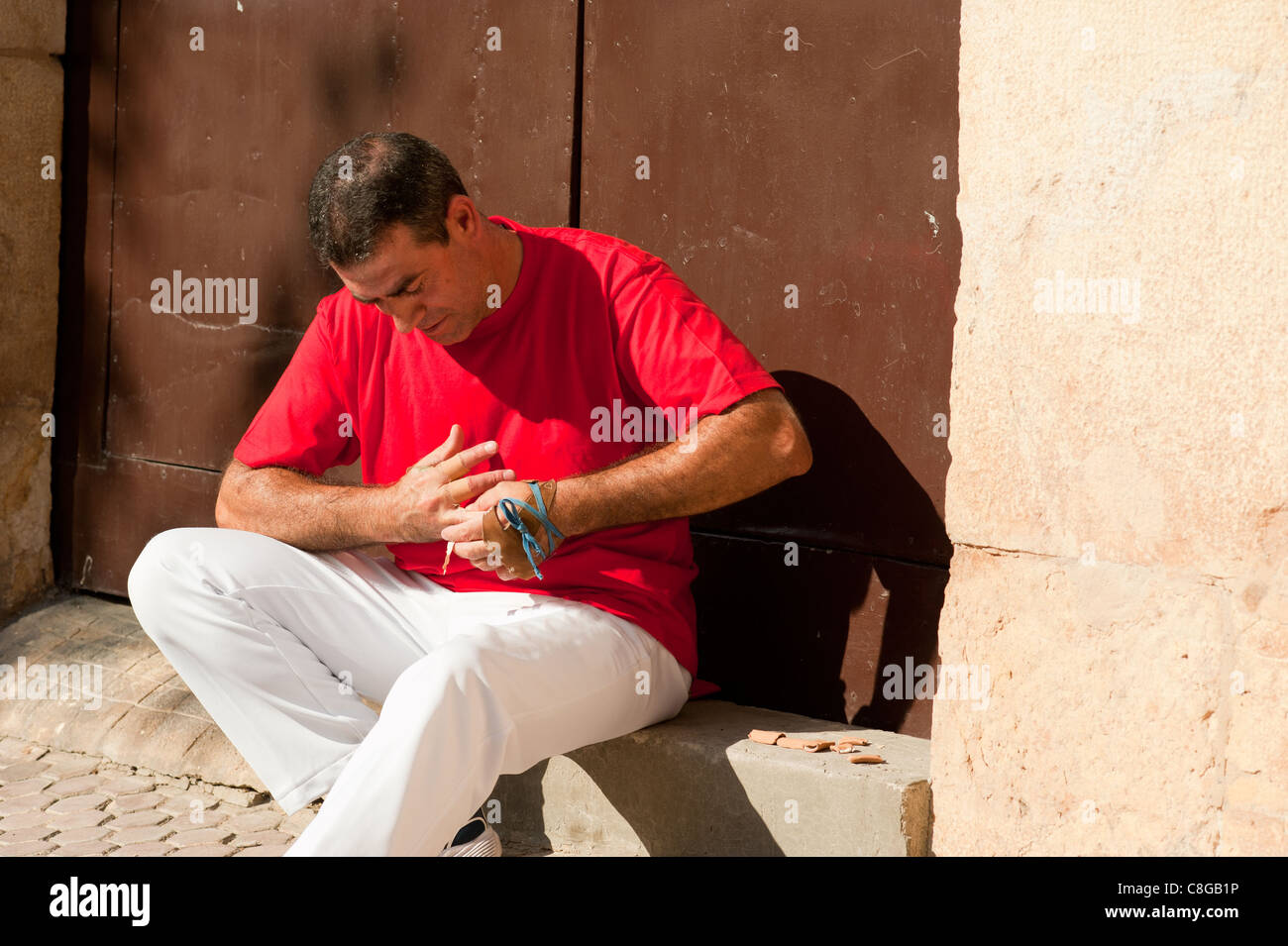 Joueur de pelote basque espagnol traditionnel rituellement enroulant ses doigts dans les protections de plâtre Banque D'Images