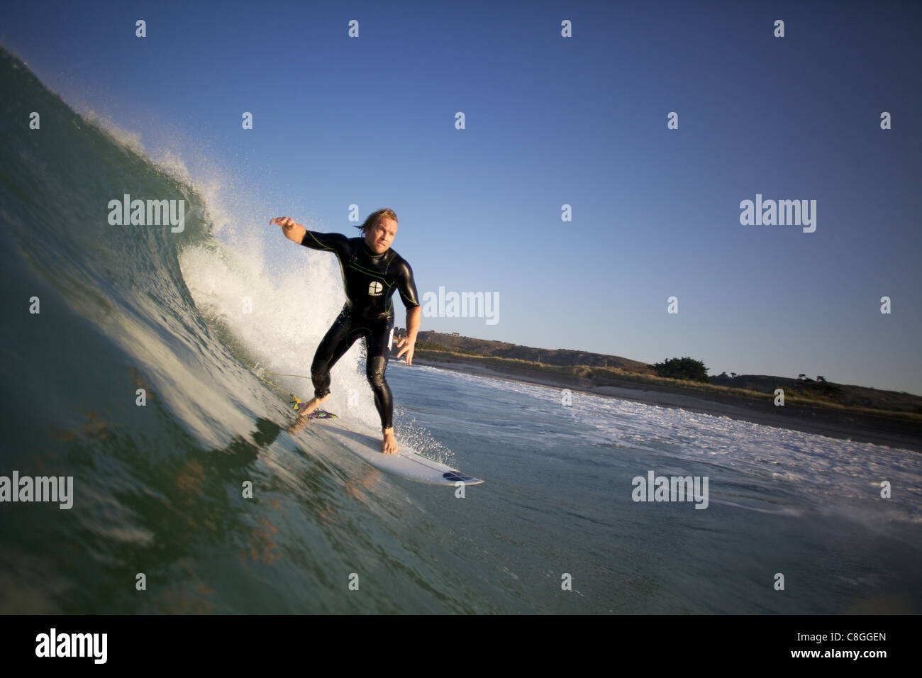 La queue pour surfer un bottom turn sur un vague tôt le matin Banque D'Images