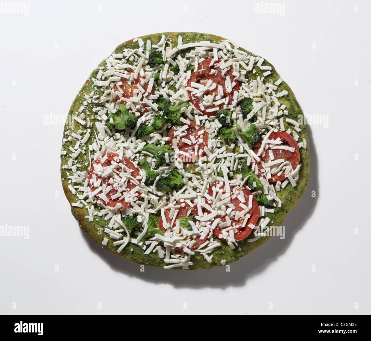 Regardant vers le bas sur une pizza congelée. Le brocoli, pepperoni, fromage et sauce pesto Banque D'Images