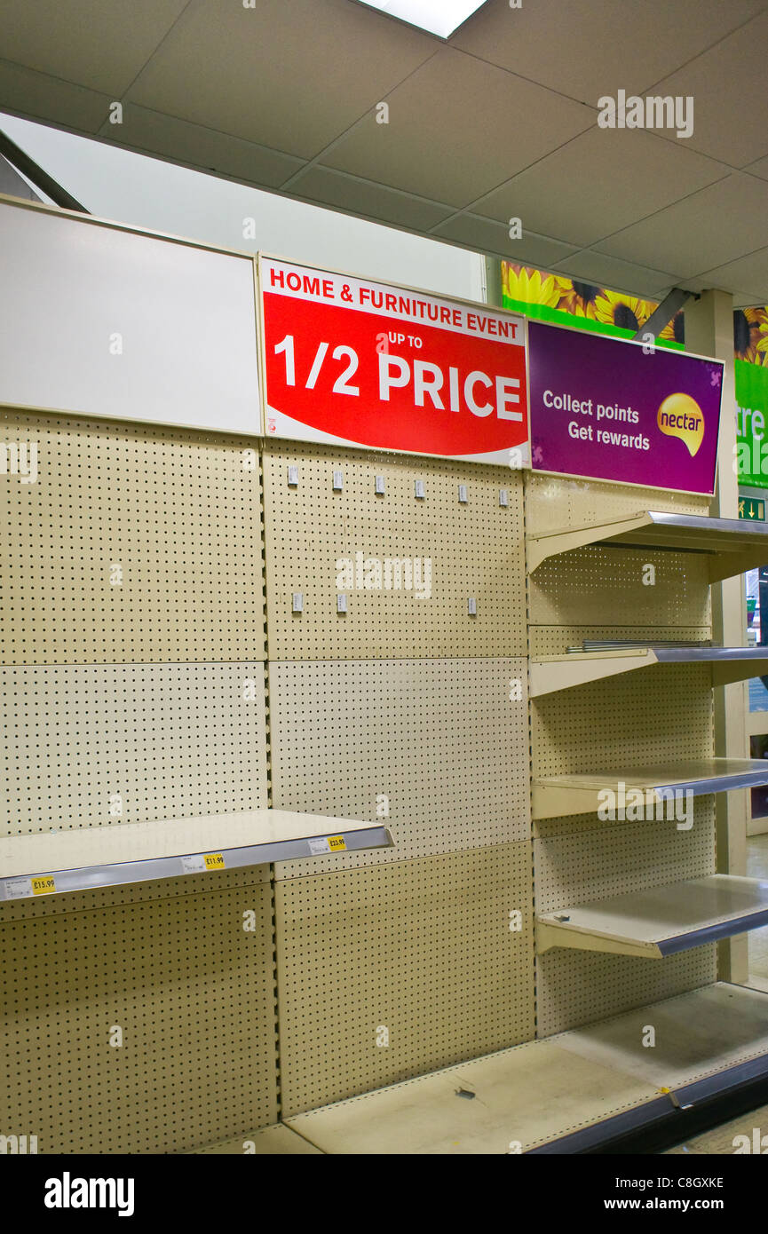 La moitié des offres de prix et des étagères vides dans un magasin Homebase, UK Banque D'Images