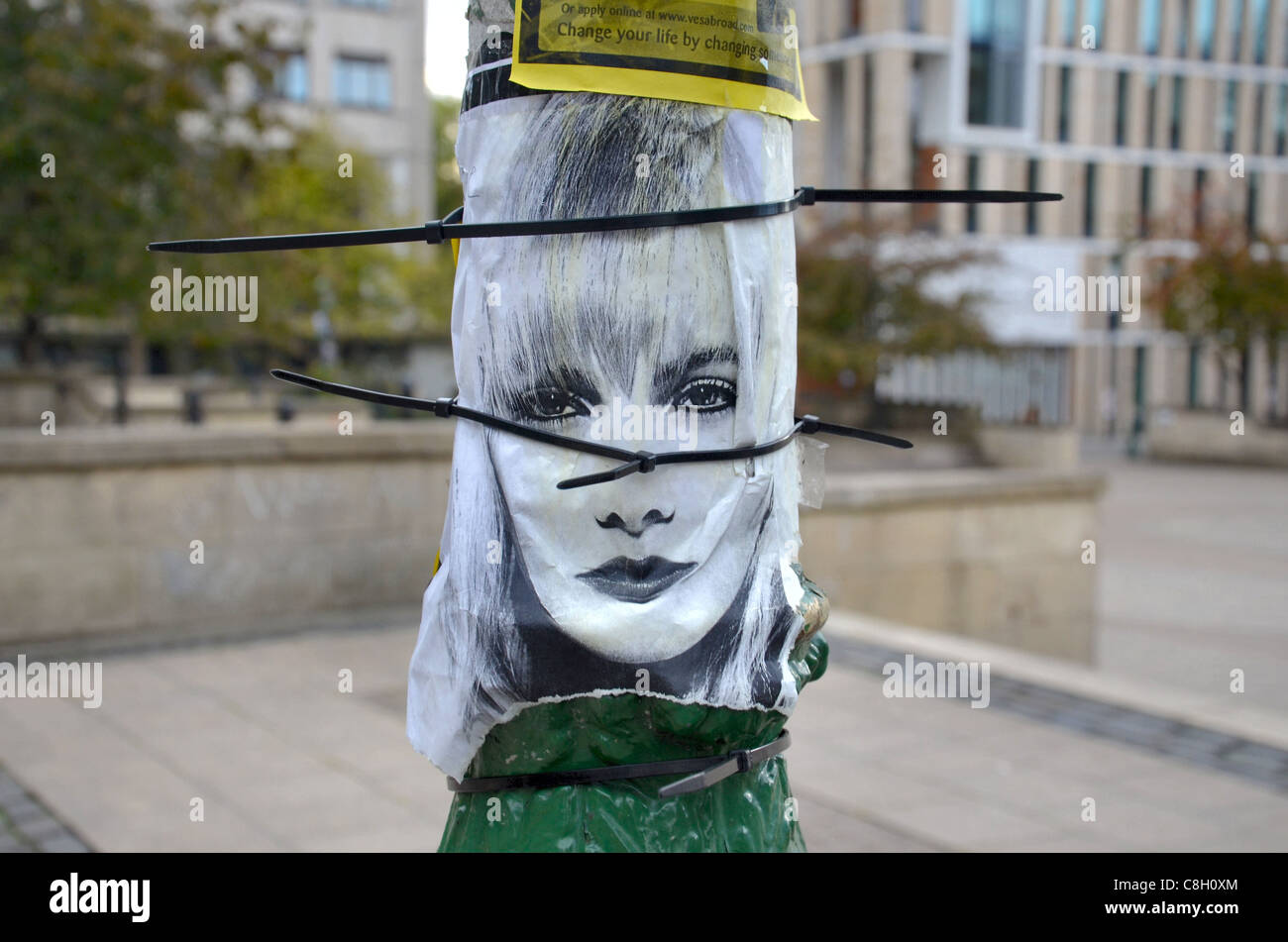 Torn affiche présentant le visage d'une femme sur un lampadaire à Édimbourg. Banque D'Images