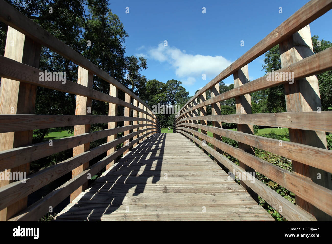 Passerelle en bois revêtus de clôture avec côtés sur une journée ensoleillée avec fond de ciel bleu Banque D'Images