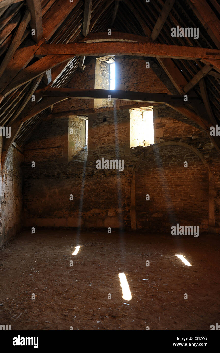 Faisceaux de lumière qui brille à travers la vitre au 14e siècle grange dîmière à Wiltshire Lacock Banque D'Images