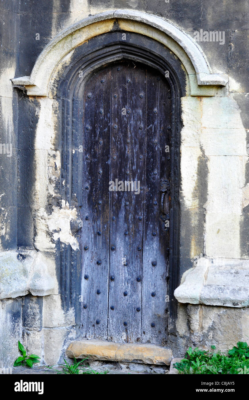 Une ancienne porte de l'église en bois cloutée au St Martins church, Stamford. Banque D'Images