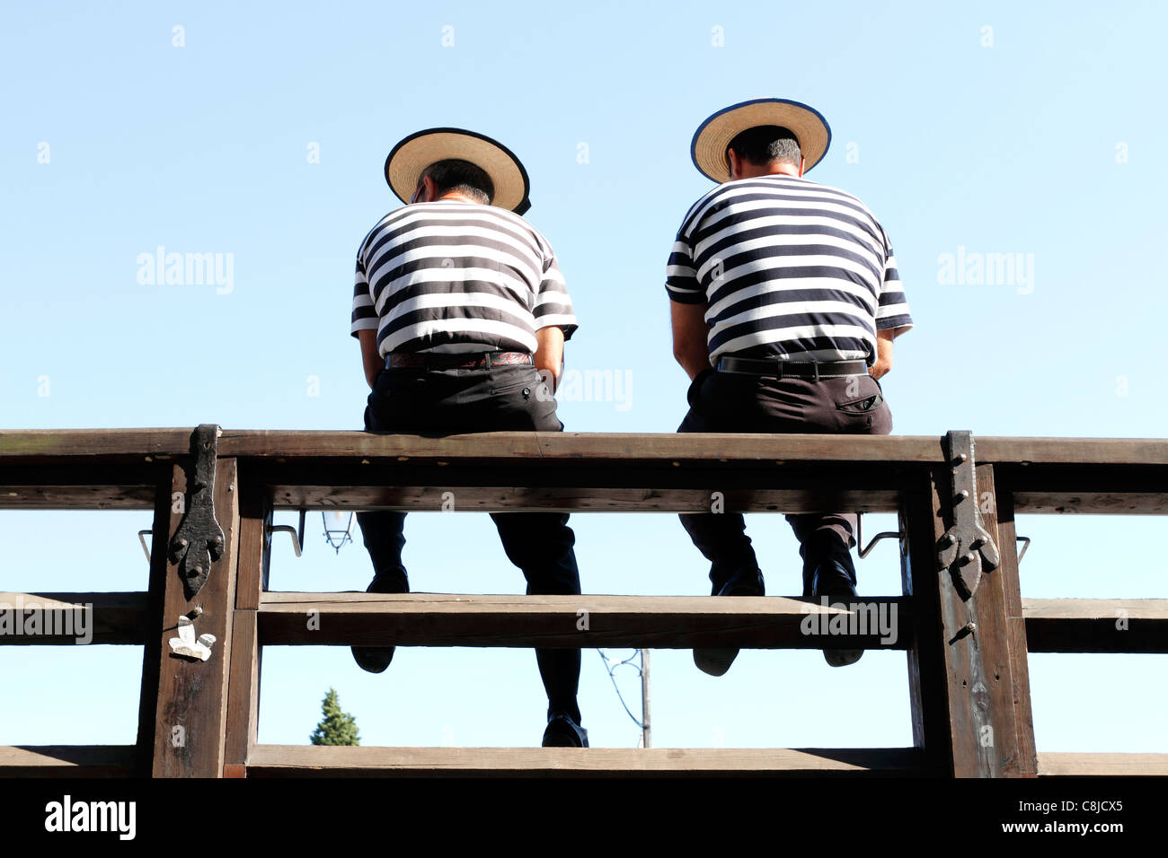 Jusqu'à à partir de ci-dessous pour 2 Gondoliers assis sur une balustrade de derrière , Venise Italie Banque D'Images
