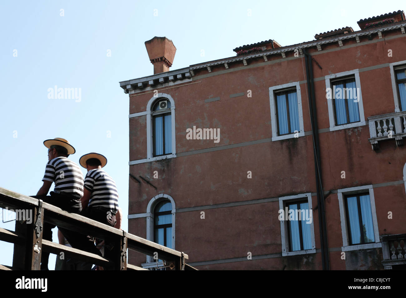 Jusqu'à à partir de ci-dessous pour 2 Gondoliers assis sur une rambarde d'un côté , Venise Italie Banque D'Images
