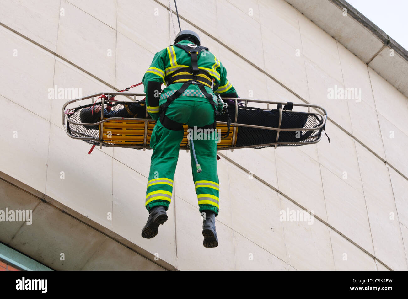 Ambulancier paramédical est ramené vers le bas d'un bâtiment sur une corde avec un patient pendant le lancement de l'Irlande du Nord Ambulance Service (NIAS) Équipe d'intervention en zone dangereuse (HART). Banque D'Images