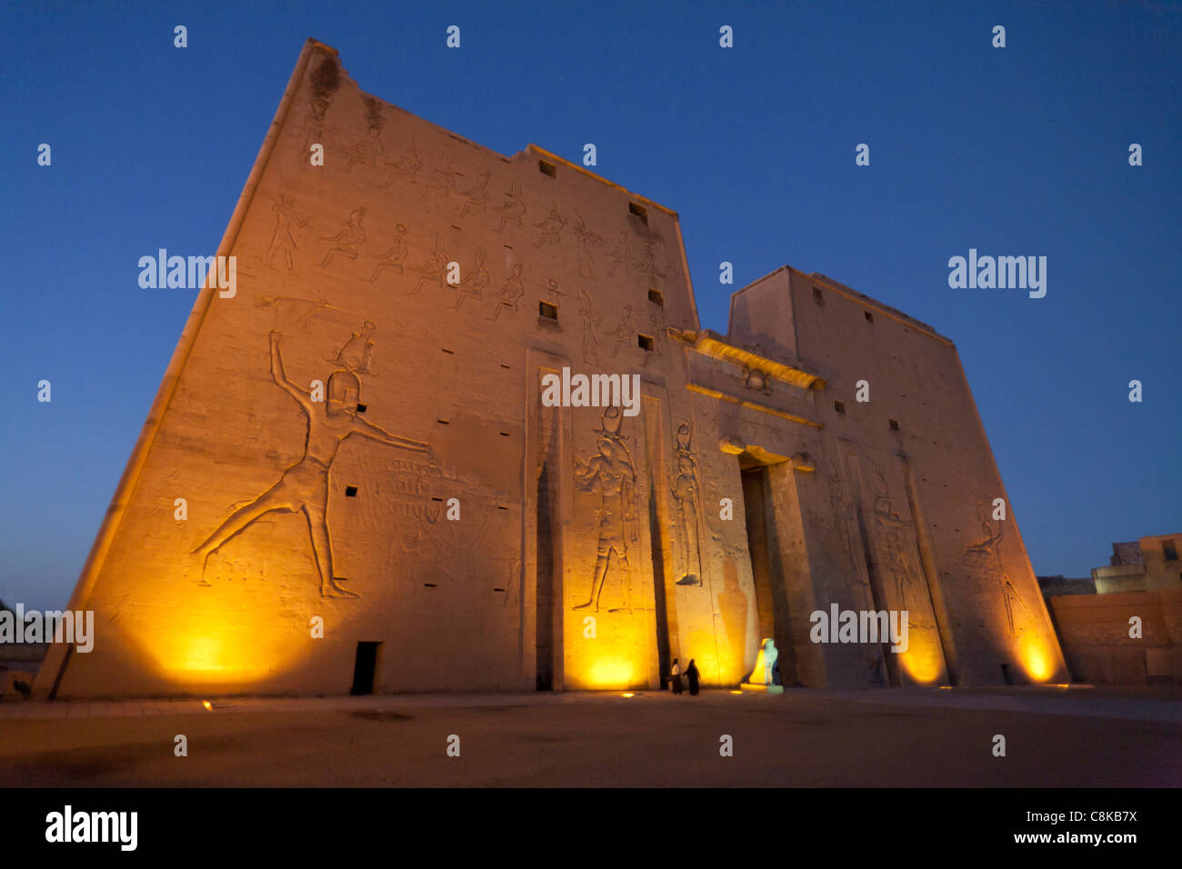 La statue d'Horus de Behdet au coucher du soleil sur le parvis à l'entrée du premier pylône, Temple d'Edfou, Edfou Haute Egypte Banque D'Images