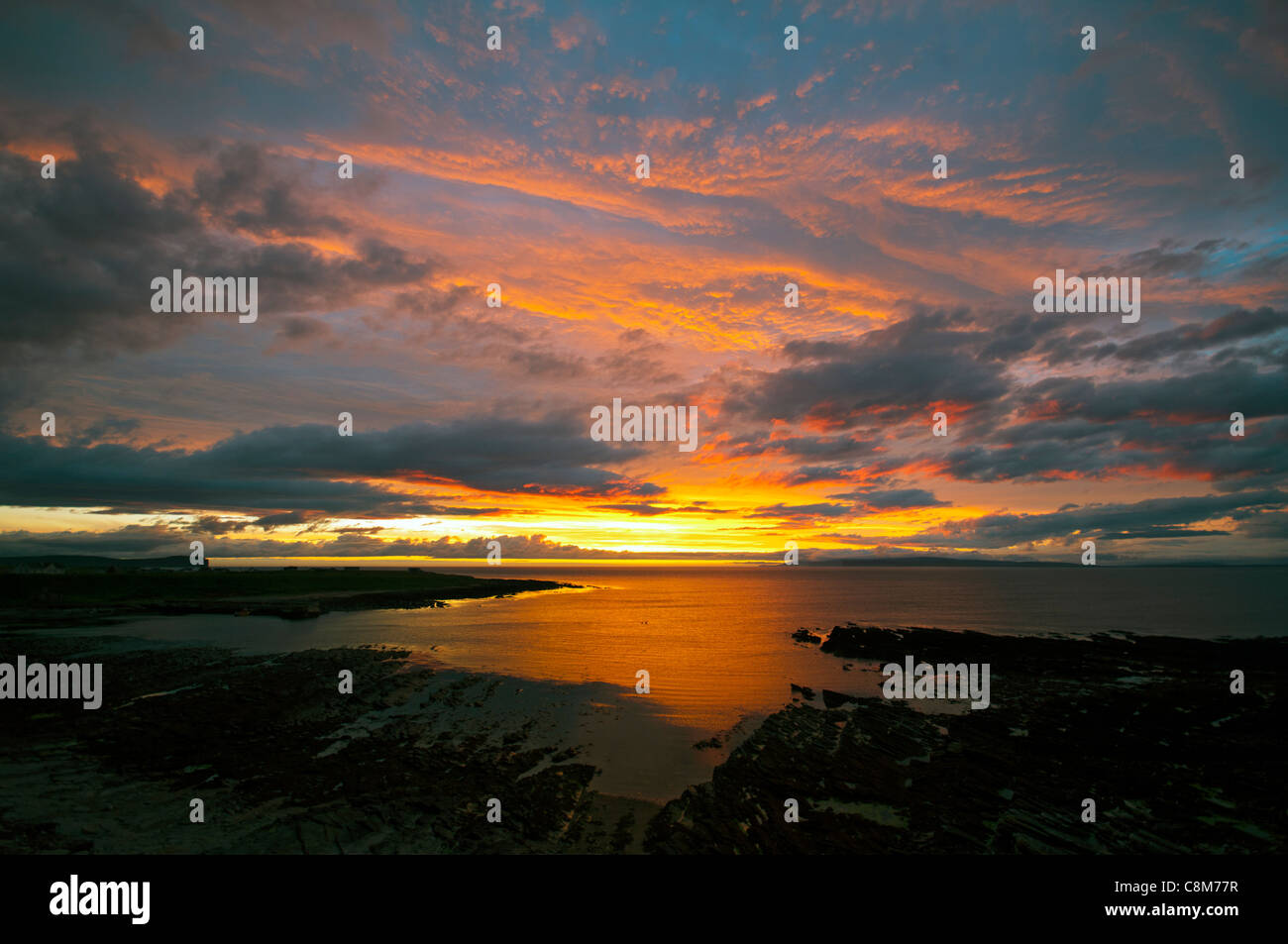 Coucher de soleil sur la Pentland Firth depuis Caithness sur la côte nord de l'Écosse, Royaume-Uni. Quelques jours après le milieu de l'été. L'île de Hoy, Orkney, à l'horizon. Banque D'Images