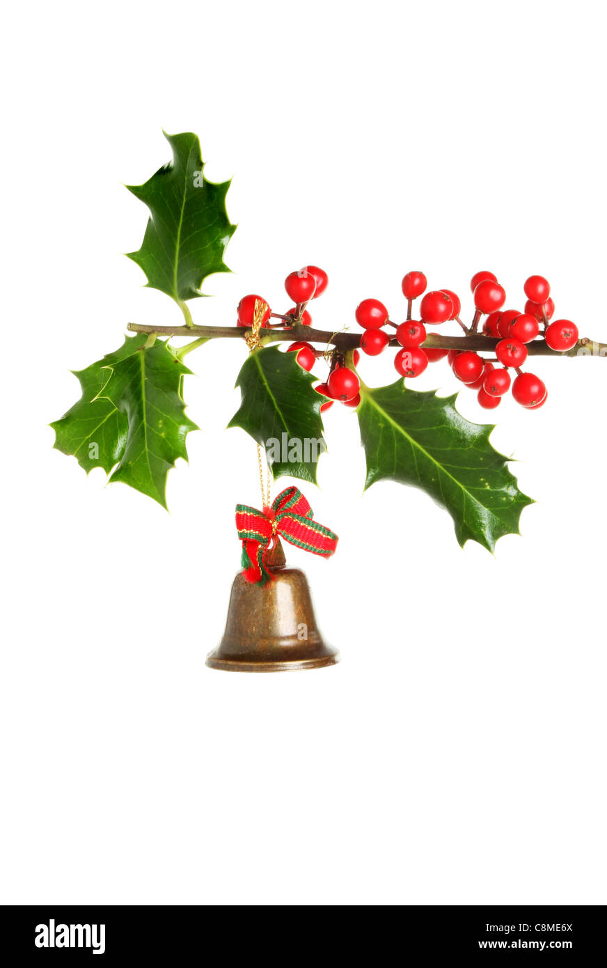 Cloche en laiton Christmas Tree ornament pendu à une branche de houx à fruits Banque D'Images