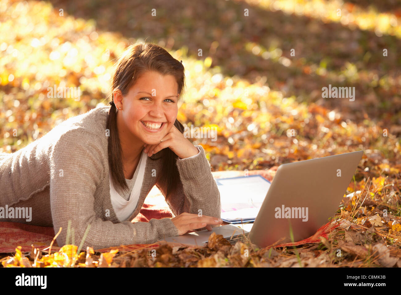 Caucasian teenager using laptop on ground Banque D'Images
